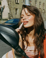 ; Stella wears the Limited Edition SPF Lip Gloss in Warm Sands