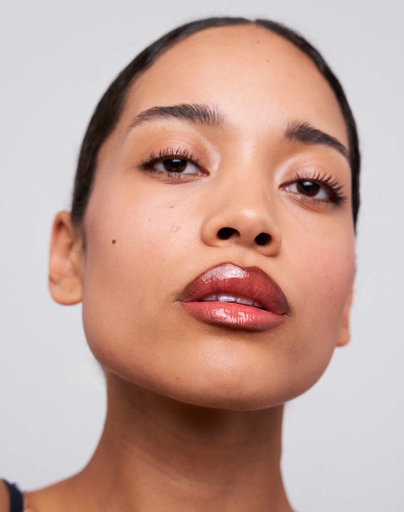 chocolate-brown; Celine wears the Soft Shape Lip Liner in Chocolate Brown and the Jelly Treat Lip Oil in Drip