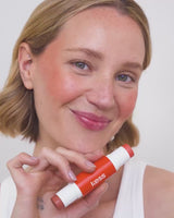 ; Jennifer wears the Hot Orange Duo Stick in Toasted and Melon