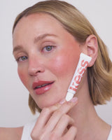 ; Jennifer draagt de Limited Edition SPF Lip Gloss in Warm Sands