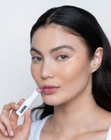 Nudie; Sarah nosi balsam do Triple Tint Lip Balm w kolorze Nudie